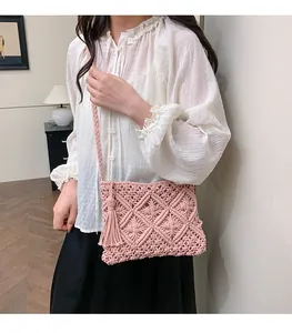 Detail of pink macrame shoulder bag showing diamond weave pattern and side fringe