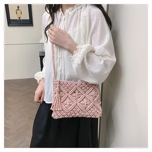 Detail of pink macrame woven bag showing cotton tassel fringe and delicate lattice pattern