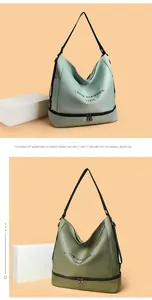Dettaglio della borsa Oxford verde con scomparto inferiore a zip e stampa del logo