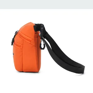 Side view of orange nylon crossbody bag with multi-zipper layers and adjustable strap