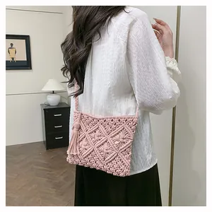Detail of pink hand-woven tassel crossbody bag featuring bohemian diamond patterns