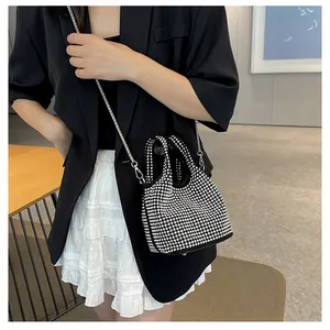 Close-up of sparkling silver rhinestones on black evening bag with metal chain strap