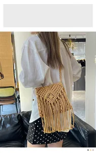 Detail of handmade bohemian straw bag featuring woven fringe and diamond pattern