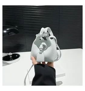 Detailaufnahme einer weißen Mini-Eimertasche aus Leder mit feiner Kieselmaserung
