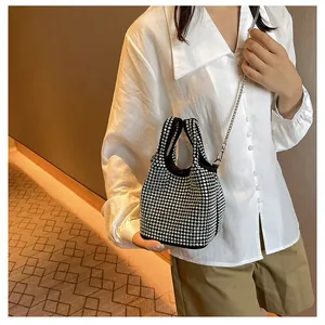 Close-up of sparkling silver rhinestone bucket bag with black trim and chain strap