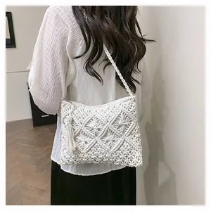 Detail of white macrame shoulder bag showing intricate diamond weave and tassels