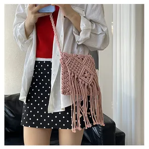 Detail of pink macrame woven bag featuring bohemian fringe and geometric patterns