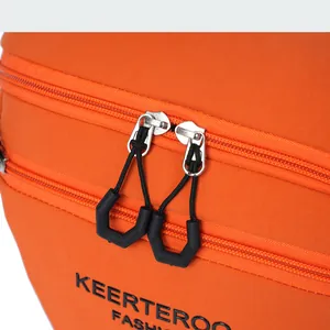 Macro detail of orange nylon crossbody bag with double zippers and black brand logo