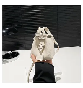 Nahaufnahme der weißen Mini-Eimertasche aus Leder mit Lychee-Muster und Silber-Schnalle