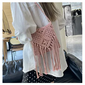 Detail of pink handmade woven shoulder bag with long bohemian fringe and geometric patterns