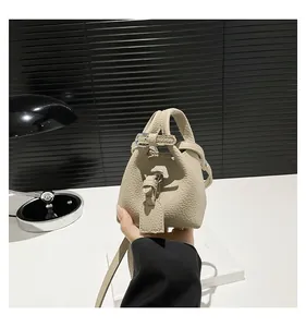 Detaillierte Makroansicht der cremefarbenen Ledertextur dieser Mini-Beuteltasche