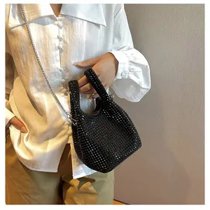 Close-up of black rhinestone bucket bag showing sparkling texture and silver chain strap