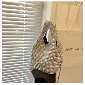 Detailed macro view of a silver rhinestone bucket bag with shiny metallic chain strap
