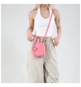 Detailed macro view of pink litchi leather texture and heart charm on the mini bucket bag