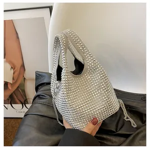 Detailed macro view of sparkling silver rhinestone bucket bag with thick carry handle