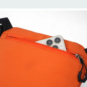 Detail of hidden back zipper pocket on orange nylon crossbody bag with a smartphone inside