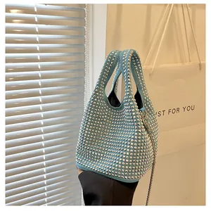 Detail of light blue bucket bag with silver rhinestones and delicate metal chain strap