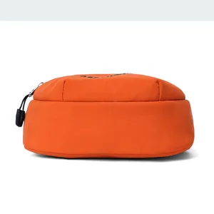 Detail view of the orange nylon crossbody bag with zipper and Reebok logo accent