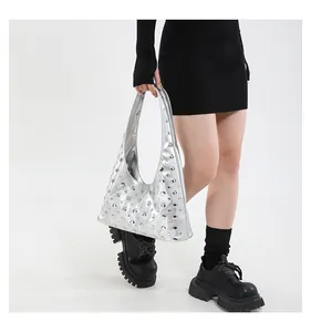 Silver studded punk tote bag styled with a black dress and loafers on a model