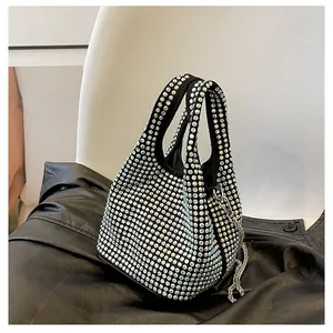 Detailed view of black bucket bag with iridescent rhinestones and silver chain accents
