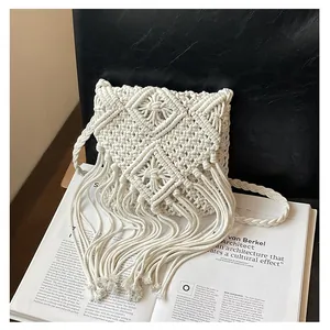 Detail of white handmade Macrame weave pattern with long bohemian fringe accents