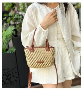 Detailed macro view of woven straw bucket bag with leather handles and fashion logo