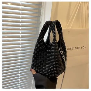 Close-up of black rhinestone bucket bag featuring sparkling crystals and a silver chain