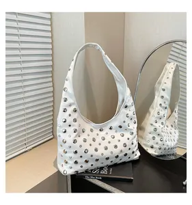 Macro detail of white hobo bag with silver metallic studs and matte leather finish