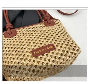 Detail of woven straw bucket bag showing brown leather handles and fashion logo tag