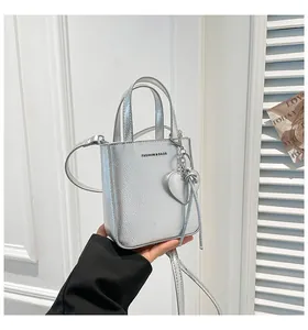 Close-up of metallic silver mini bucket bag with litchi texture and heart charm