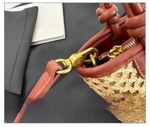 Detailed close-up of premium golden hardware and woven straw texture on the bucket bag