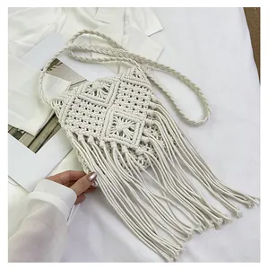 Detailed macro view of bohemian ivory macramé woven cotton bag with diamond mesh and long tassels