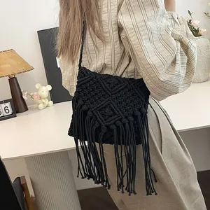 Handmade black macrame crossbody bag with diamond patterns and long bohemian fringe
