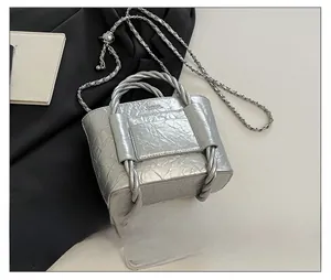 Silver wrinkled leather mini bucket bag detail with chain strap and phone for size reference