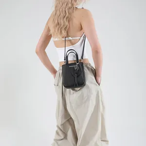 Chic black litchi grain bucket bag with heart stitching shown on a model