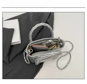 Detail of silver textured bucket bag showing spacious interior for phone and wallet