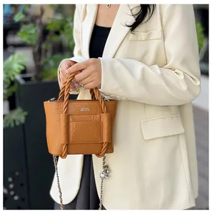 Close-up of brown textured bucket bag featuring woven handle and classic logo text