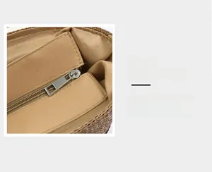 Close-up of smooth silver metal zipper and woven texture on a khaki straw tote bag