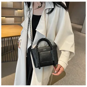 Detail view of the black wrinkled texture bag with woven handle and leather chain strap