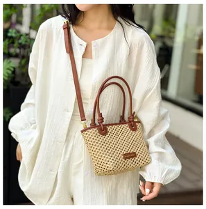Straw woven mini bucket bag with leather strap shown in a sunny outdoor setting