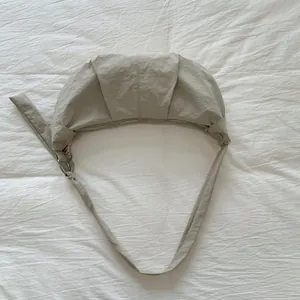 Draufsicht auf die aprikosenfarbene Nylon-Halbmondtasche mit Falten und silbernem Reißverschluss