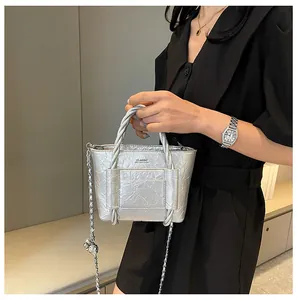 Silver bucket bag with pleated texture, twisted handle and metallic chain strap detail