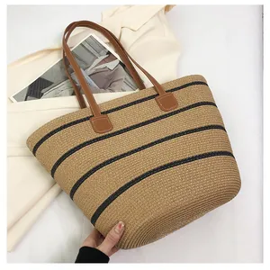Macro detail of the woven straw texture and stylish black stripes on the tote bag