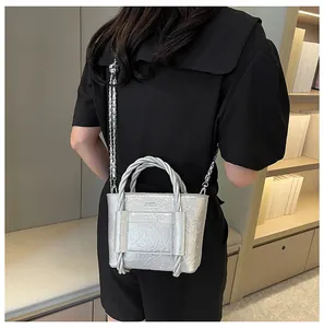 Detailed back view of a silver crinkled leather bag with woven handle and chain strap