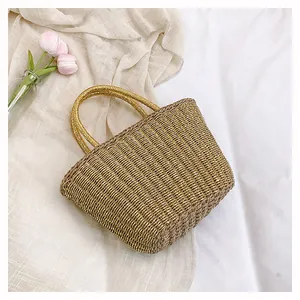 Vue détaillée d'un sac à main tressé doré avec reflets métalliques et anses arrondies