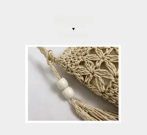 Detail of hollow star woven straw bag with wooden beads and fringed tassel accents
