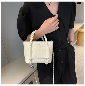 Detail view of off-white wrinkled leather bucket bag with woven handle and chain strap
