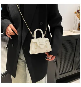 Nahaufnahme weiße Mini-Handtasche mit goldener Kugelkette und Nietendetails
