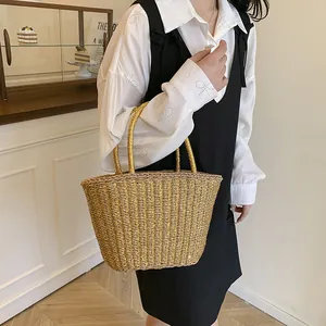 Sac cabas doré en paille tressée pour vacances à la plage avec des poignées cylindriques