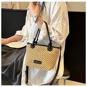 Detail of khaki woven bucket bag featuring black leather trim and adjustable strap